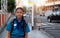 Schoolgirl in thai red cross youth uniform with backpack on the footpath