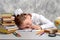 The schoolgirl tired to do homework task and fell asleep at the table. Child education concept.