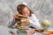 The schoolgirl tired to do homework task and fell asleep at the table. Child education concept.