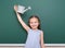 Schoolgirl with watering can play near a blackboard, empty space, education concept