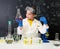 Schoolgirl in white gown doing experiments with liquids