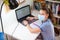 Schoolgirl working on laptop while sitting at home, child wearing medical mask suring self-isolation