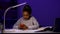 A schoolgirl writes her homework, picks up her phone to check messages and reply, and continues to study. A child at the