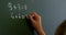 Schoolgirl writing on chalkboard with chalk in classroom at school 4k