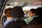 Schoolgirl and young woman interacting in car on their way to school