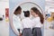 Schoolgirls looking in a magnifying mirror at science centre