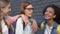 Schoolgirls pushing shoulders of smart female student, mocking nerd in glasses