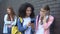 Schoolgirls reading humiliating news about classmate smartphone pointing finger