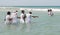 Schoolgirls in uniform playing in the sea