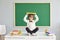 Schooling. Back to school. Funny schoolboy holds a book over his head while sitting on a desk at school