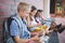 Schoolkids sitting in corridor and using mobile phone