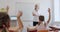 schoolkids sitting at desks in classroom and listen to the teacher.