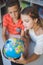 Schoolkids studying globe in library