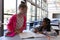 Schoolkids talking with each other at desk in classroom