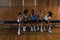 Schoolkids talking with each other and sitting on bench at basketball court