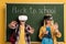 Schoolkids with Virtual reality headsets standing near chalkboard with back to school lettering