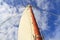Schooner mast and sail in blue sky