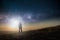 A science fiction concept. A man standing on a hill looking out across space with a bright light in the sky