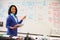 Science Teacher Standing At Whiteboard With Digital Tablet