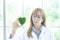 Science whit green spirit mind. Green heart in her hand on lab a background. Beautiful smiling female doctor. The woman is in the