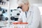 Science woman, microscope and medical analysis in a laboratory with scientist for investigation or research. Expert