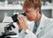 Science, woman study and microscope for lab research and studying virus in a hospital or clinic. Scientist, medical and