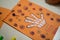 scientific activity for children, drawing and collage of the bones of the hand. On a decorated orange sheet a hand was drawn and