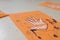 scientific activity for children, drawing and collage of the bones of the hand. On a decorated orange sheet a hand was drawn and