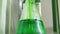 Scientific chemical experiment with green liquid and glass bottle in the laboratory.