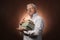 Scientific thinker, philosophy, elderly gray-haired man in a white shirt with a books, with studio light