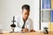 Scientific young woman looking at you while working at laboratory with a microscope.