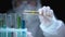 Scientist adding liquid from test tube with warning symbol, dangerous research