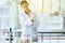 Scientist beautiful women putting rubber gloves on hands for working medical chemicals sample on microscope at laboratory