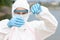 Scientist or biologist takes water sample near an industrial plant closeup