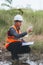 Scientist Ecologist taking a water sample and reading ph value at river. Water pollution and conservation and management of water