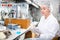 Scientist engaged in research in chemical laboratory, noting results in test chart