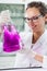 Scientist examining flask with violet liquid