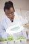 Scientist examining sprouts under heat lamp