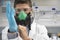 Scientist In Gas Mask And Putting On Rubber Glove