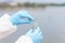 Scientist in gloves and protective suit pours dirty water from test tube into flask