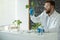 Scientist holding and examining samples with plants, young sample plant growing in test tube, biotechnology research