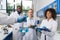 Scientist Holding Flask With Group Of Students Taking Notes Making Research In Laboratory, Mix Race Team Of Doctors