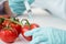 Scientist holding syringe and making experiment with vegetables in lab