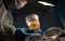 A scientist holds a chicken yolk in a transparent cup.