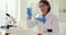 Scientist holds in hands flask with a transparent liquid in laboratory