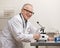 Scientist in lab coat with microscope