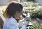 Scientist looking at microscope in greenhouse