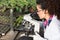 Scientist looking at microscope in greenhouse