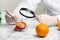 Scientist with magnifying glass exploring plum in laboratory  closeup. Poison detection