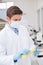 Scientist measuring corn with gloves and protective mask